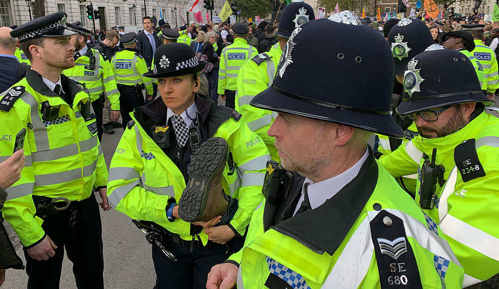 There are a number of police officers carrying a protester away in the city.