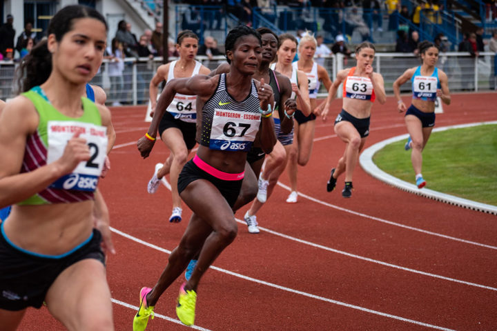 Female athletes are racing on a track.