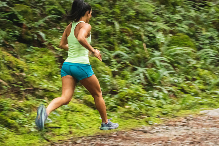 A woman in sportswear is running along a country path.