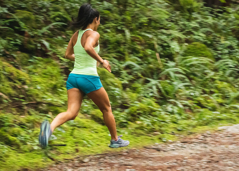 A woman in sportswear is running along a country path.