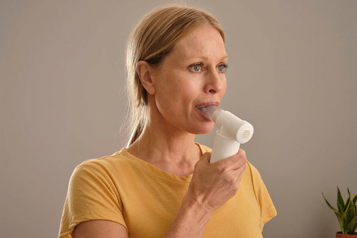 lady using POWERbreathe Medic breathing device