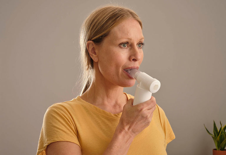 lady using POWERbreathe Medic breathing device