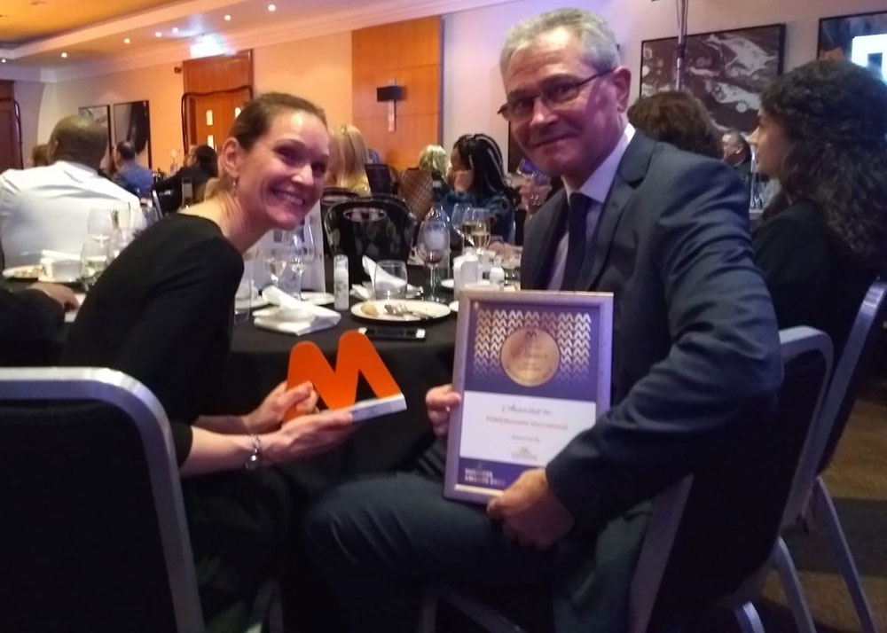 two people from POWERbreathe International at table with business award