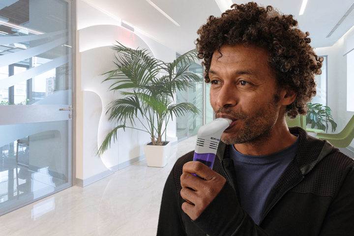 man in room using powerbreathe EMT device