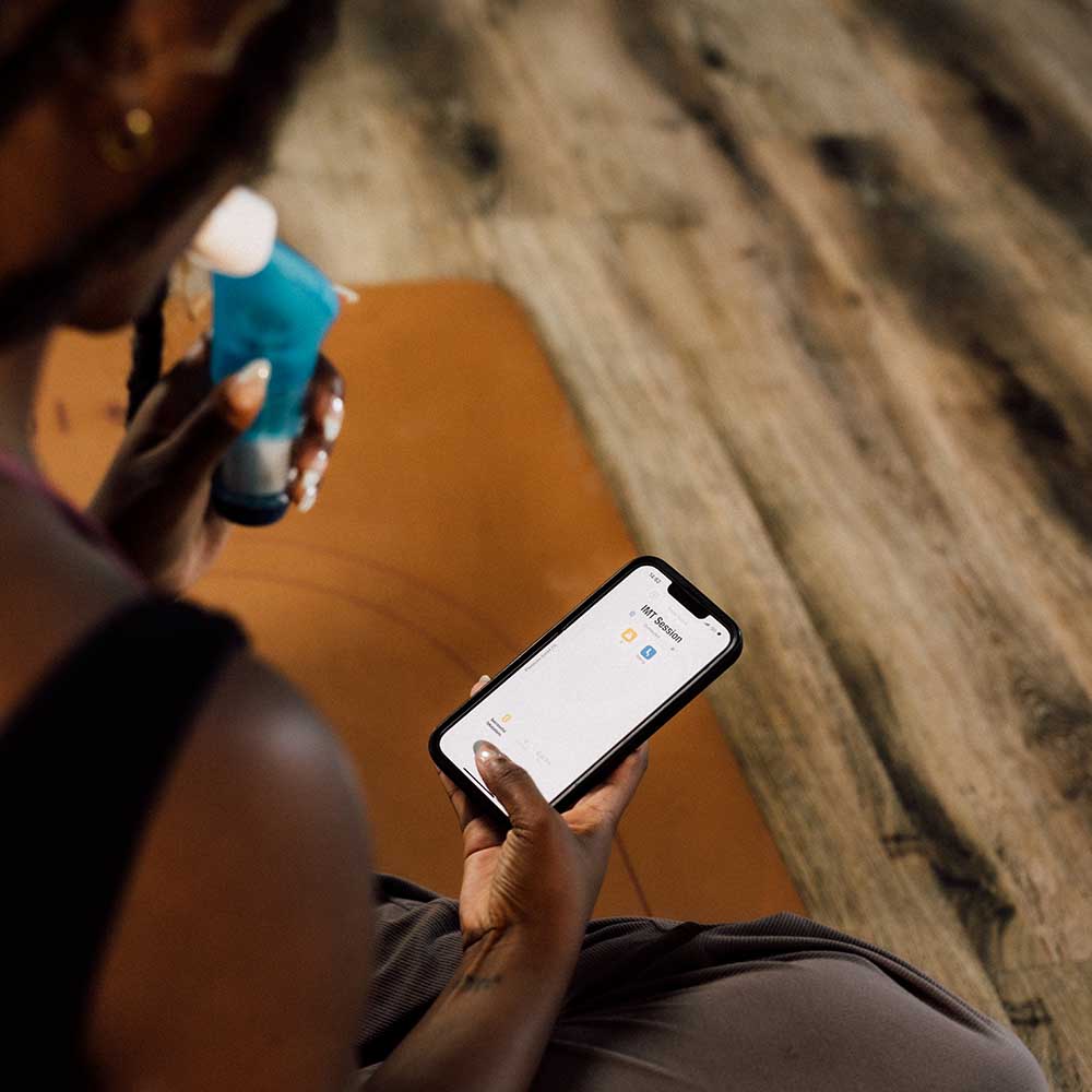 An over the shoulder view of a lady looking at a Smart Adaptor App screen