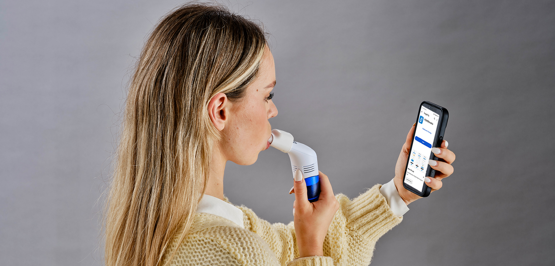 person using powerbreathe ex1 device while installing app on mobile