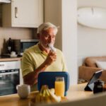 A man sat at a breakfast table using a Plus and a Smart Adaptor