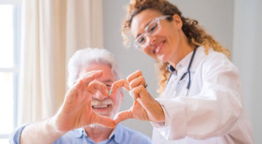 Cardiac patient making a heart shape with fingers of doctor