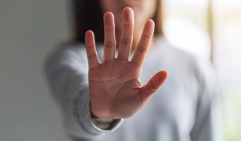 A hand held up, palm out implying a halting signal