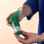 Close-up of 2 hands holding the Green Plus Light