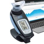 The POWERbreathe K4 offers a professional level of breathing training, testing and monitoring. Shows a partial laptop next to it.