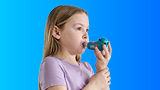 Child breathing out through the Shaker Deluxe Kids mucus clearance device.