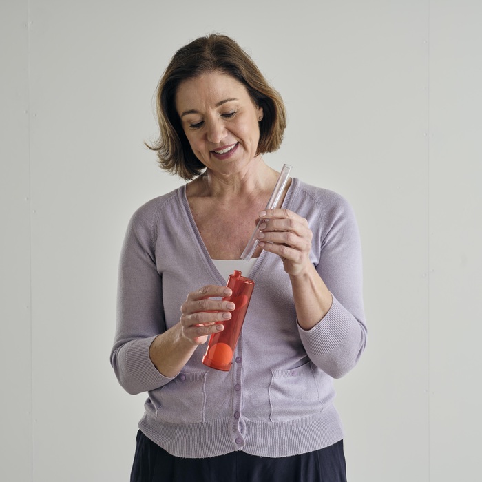 A woman who looks like she is attaching the tube to a Breath Builder